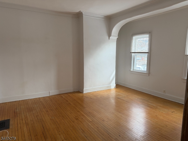 59 Walnut Street, Unit 1 Montclair, NJ 07042 - Photo 3 of 8 a view of an empty room with wooden floor and a window