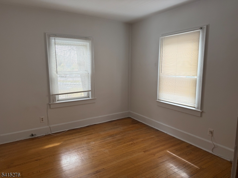 59 Walnut Street, Unit 1 Montclair, NJ 07042 - Photo 5 of 8 a view of an empty room with wooden floor and a window