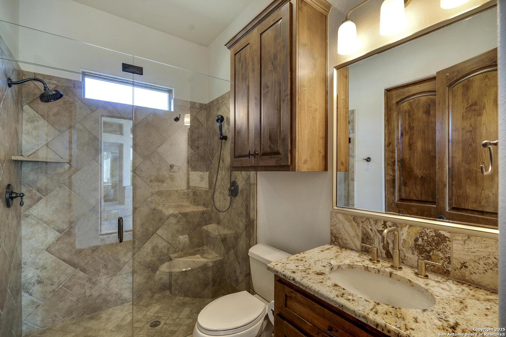 307 Augusta Boerne, TX 78006 - Photo 43 of 90 a bathroom with a granite countertop sink toilet and shower