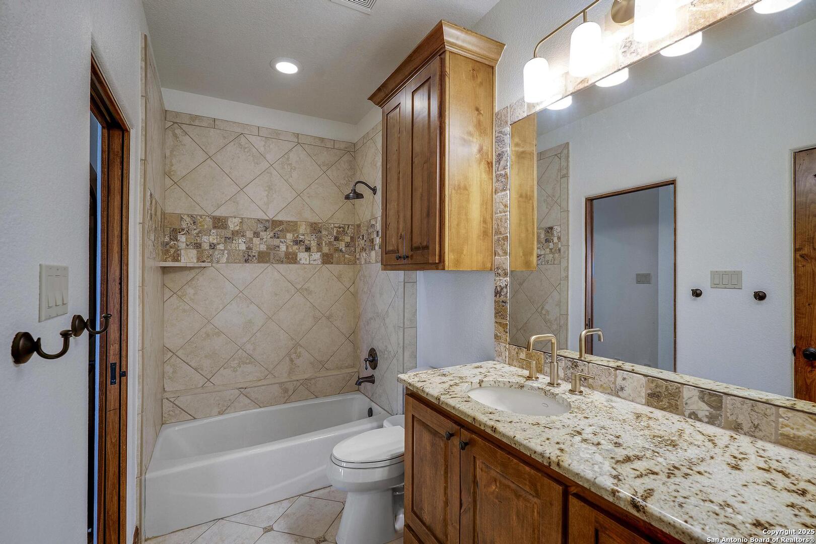 307 Augusta Boerne, TX 78006 - Photo 54 of 90 a bathroom with a granite countertop sink toilet and shower
