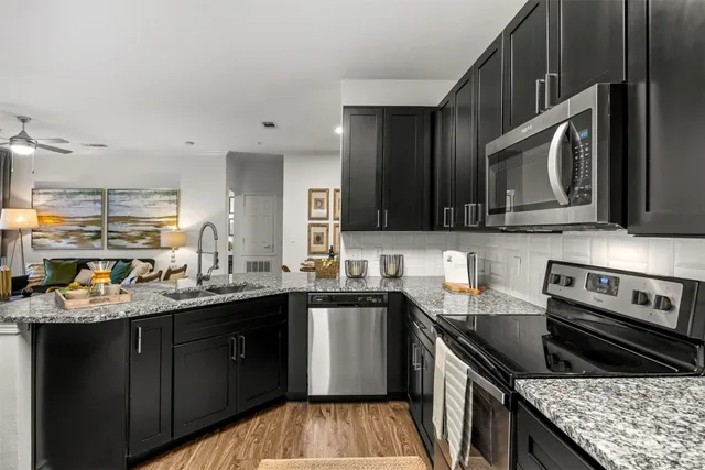 a kitchen with stainless steel appliances granite countertop a sink stove and cabinets