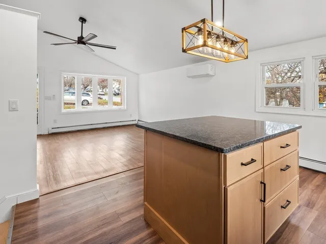 a view of kitchen with granite countertop cabinets a window and a dining table