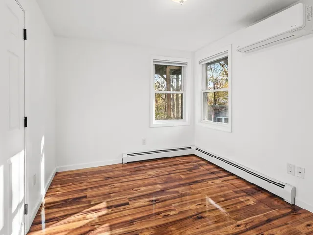 a view of a room with wooden floor and windows