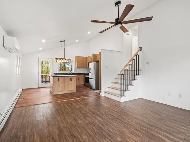 a view of a kitchen with wooden floor and electronic appliances