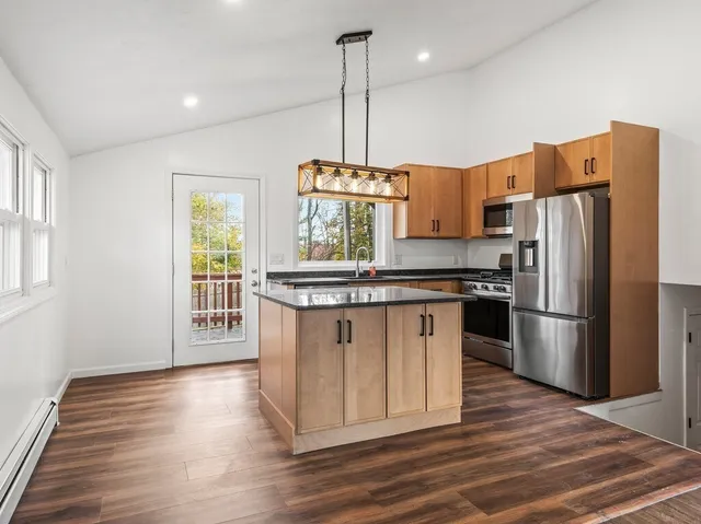 a kitchen with stainless steel appliances granite countertop a refrigerator a stove a sink dishwasher and a refrigerator with wooden floor