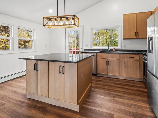 a kitchen with granite countertop white cabinets and window