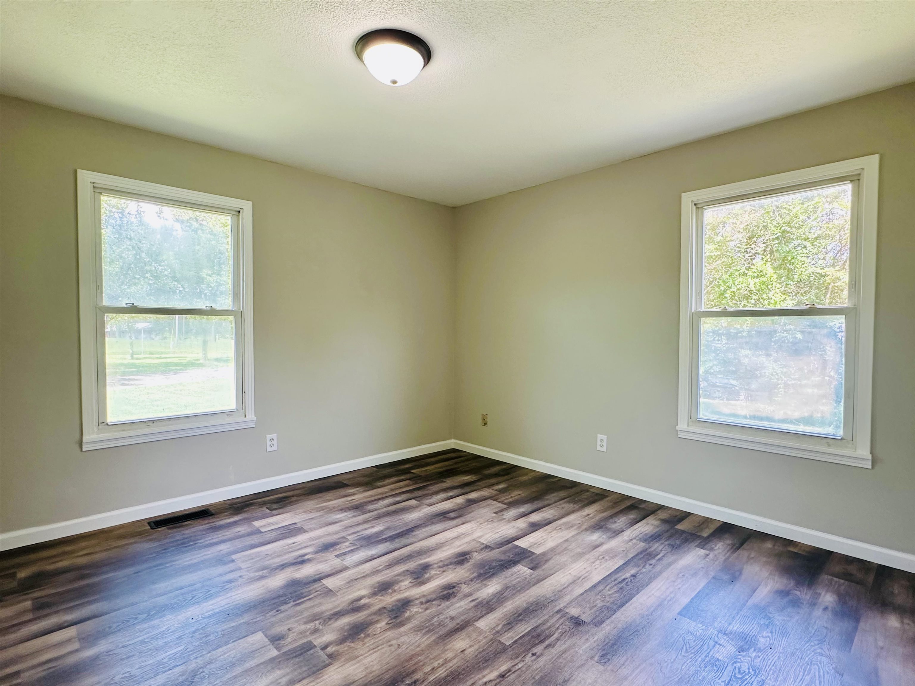 287 Gilchrist Stantonville Road Adamsville, TN 38310 - Photo 11 of 29 an empty room with wooden floor and windows