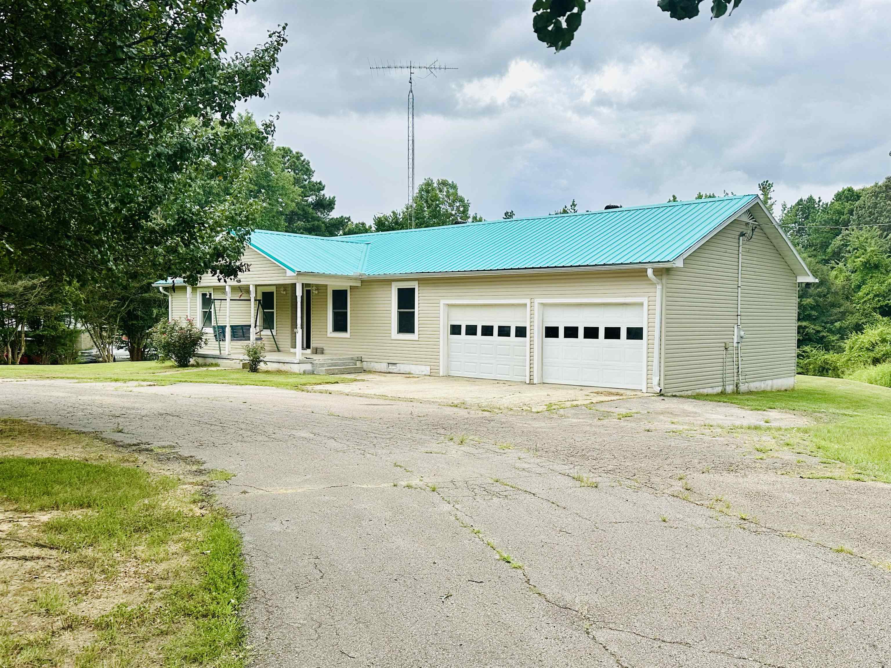 287 Gilchrist Stantonville Road Adamsville, TN 38310 - Photo 18 of 29 Single story home with covered porch, a garage, a metal roof, and driveway