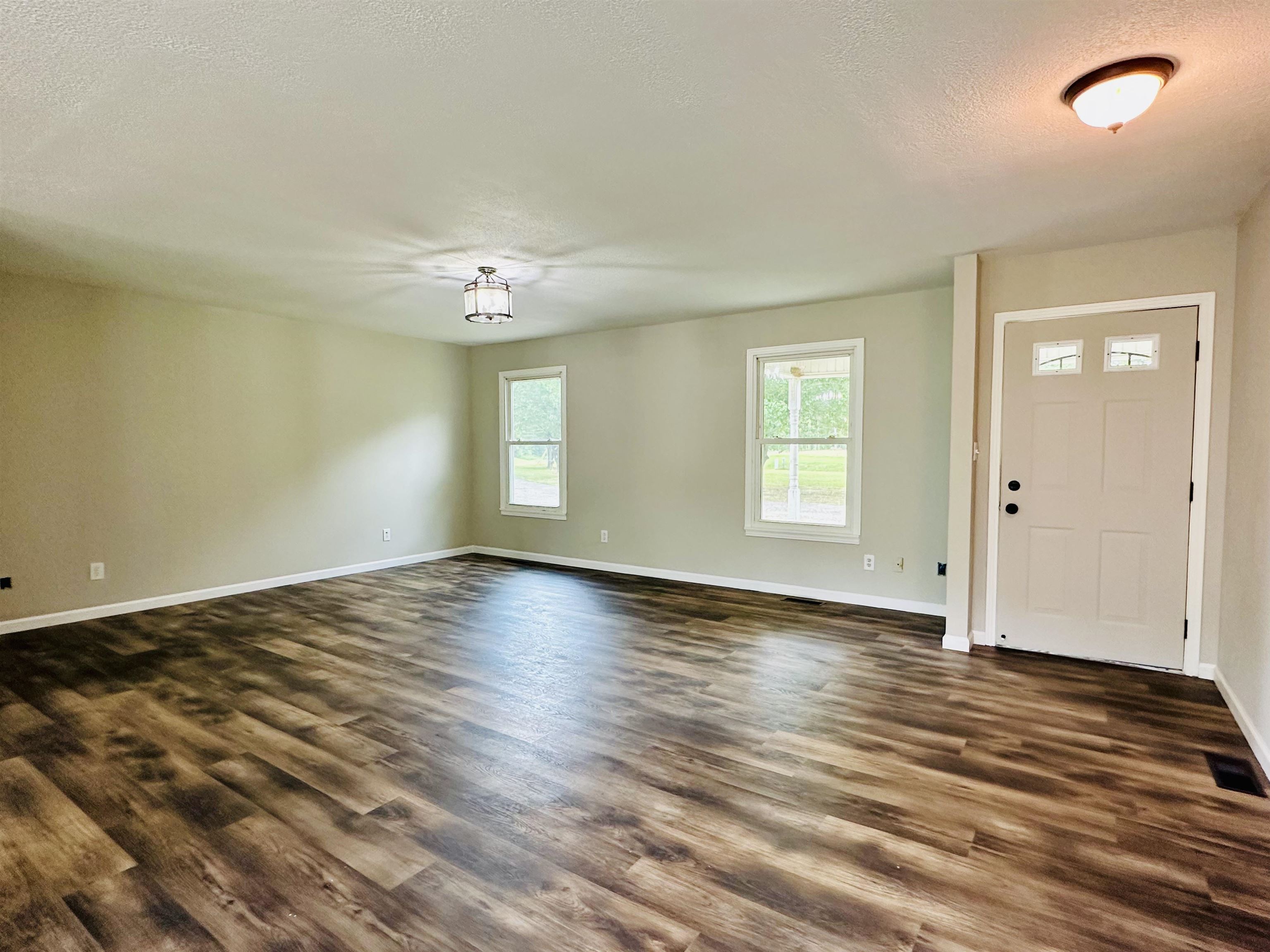 287 Gilchrist Stantonville Road Adamsville, TN 38310 - Photo 2 of 29 an empty room with wooden floor and windows