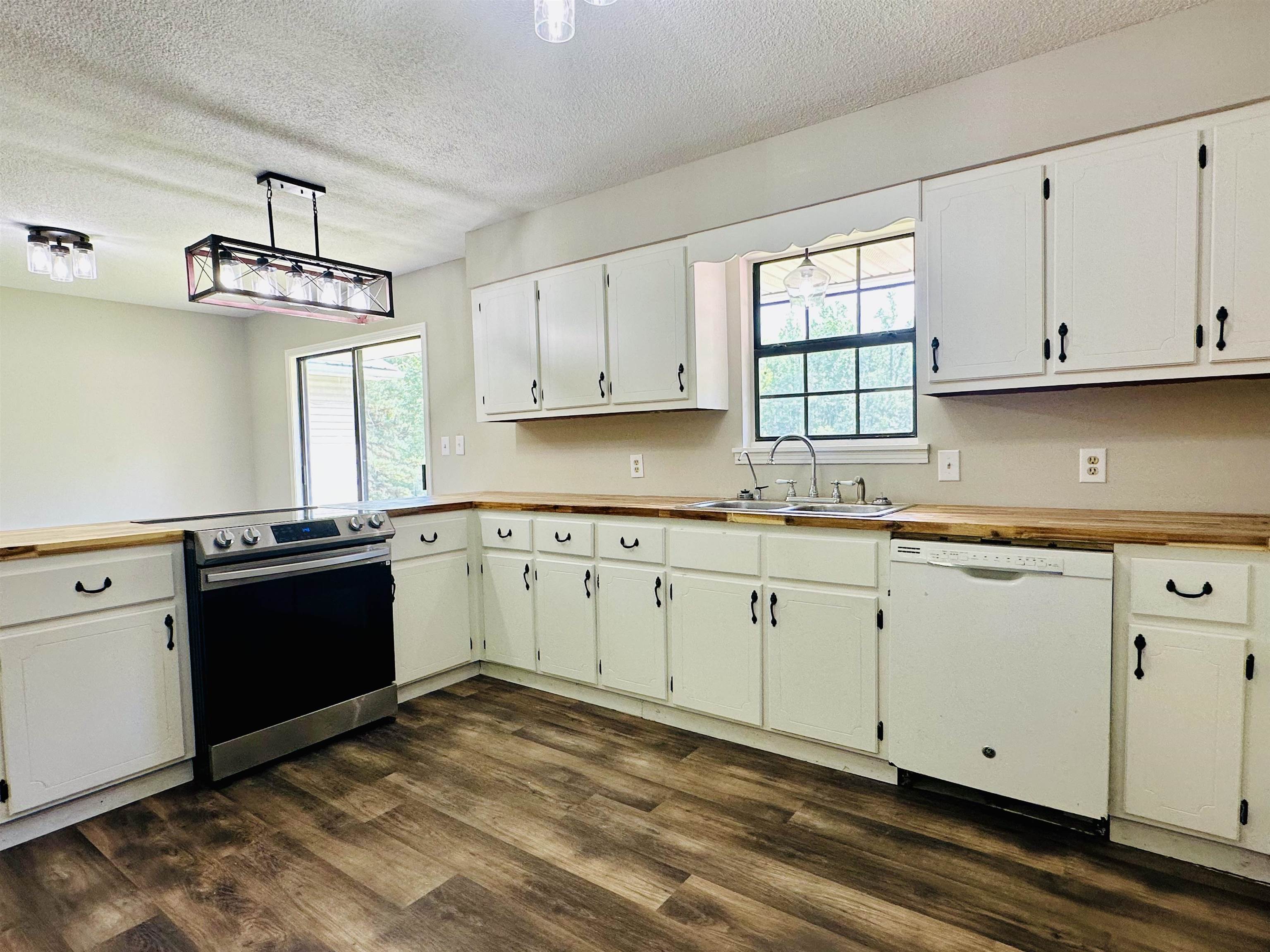 287 Gilchrist Stantonville Road Adamsville, TN 38310 - Photo 22 of 29 a kitchen with granite countertop white cabinets and black stainless steel appliances