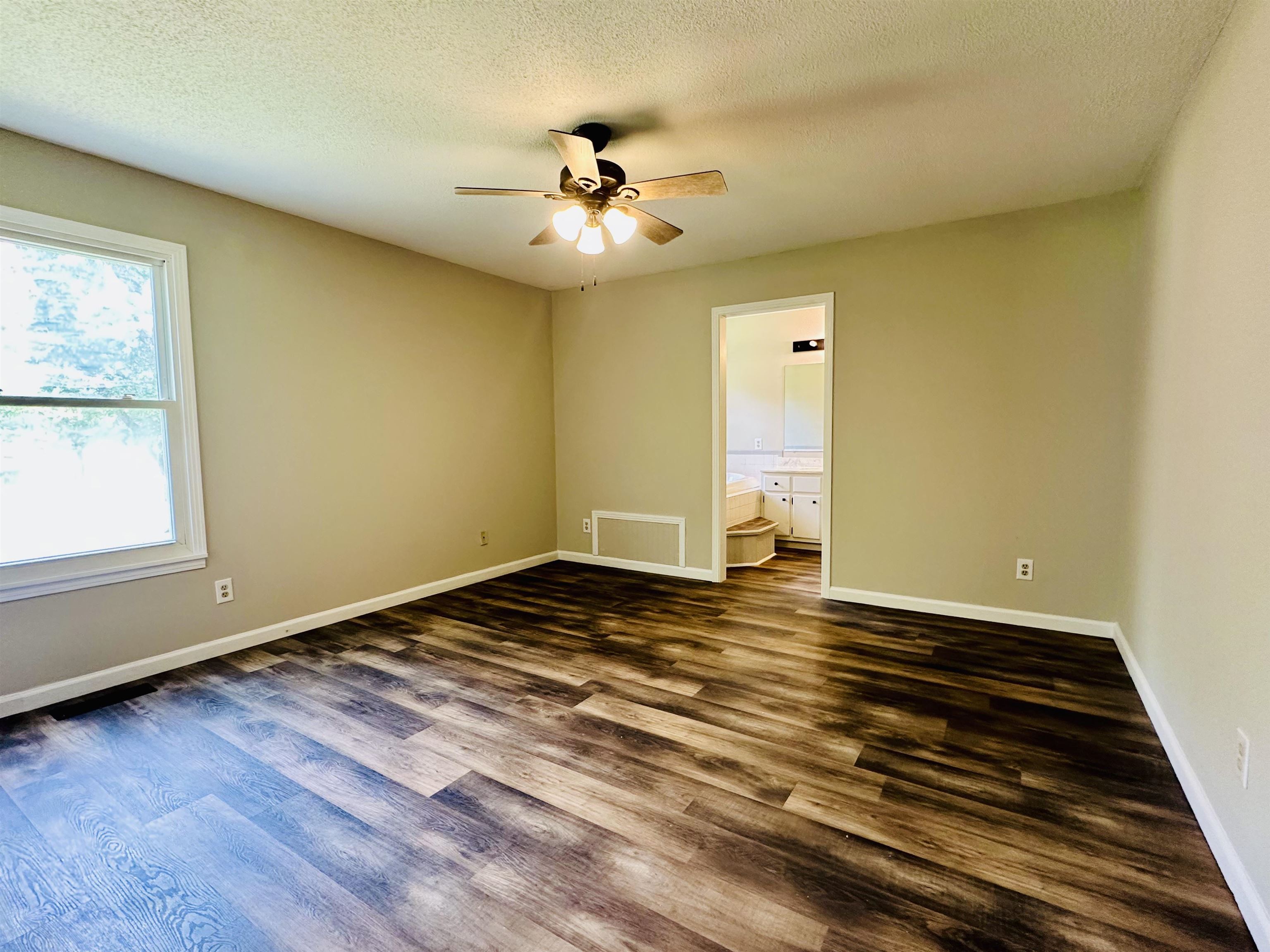 287 Gilchrist Stantonville Road Adamsville, TN 38310 - Photo 9 of 29 a view of an empty room with wooden floor and a window