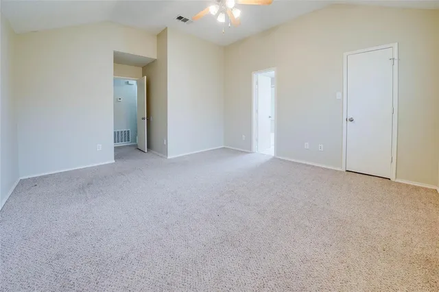 a view of an empty room with a chandelier fan