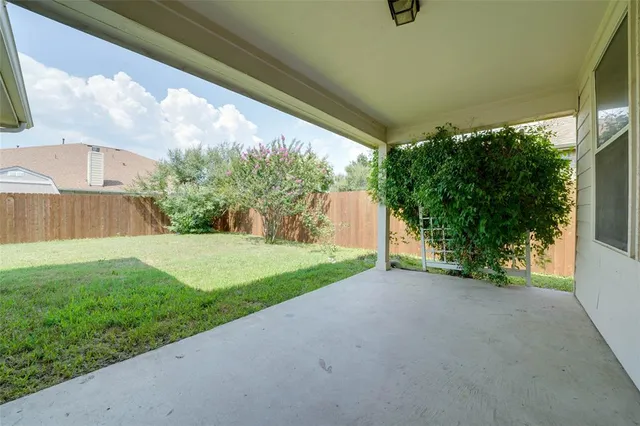 a view of a house with backyard and a tree