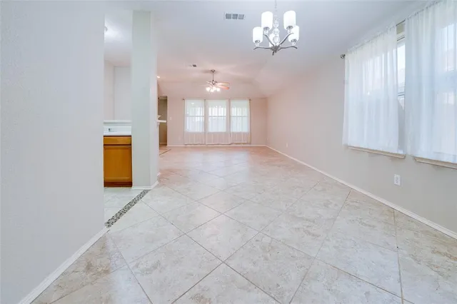 en empty room with windows and ceiling fan