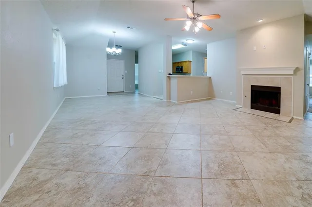 an empty room with a fireplace and fan