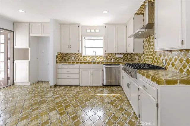 a large kitchen with granite countertop a sink and a stove