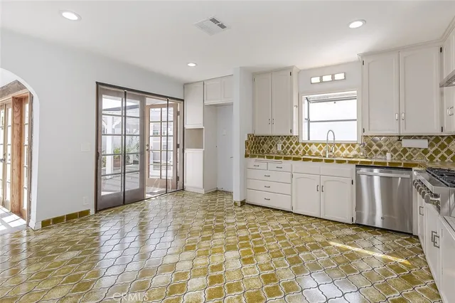 a kitchen with stainless steel appliances granite countertop a stove a sink and a cabinets