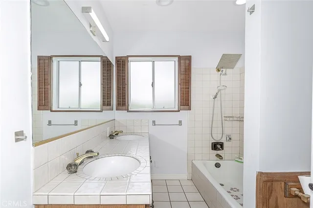 a bathroom with a tub sink and mirror