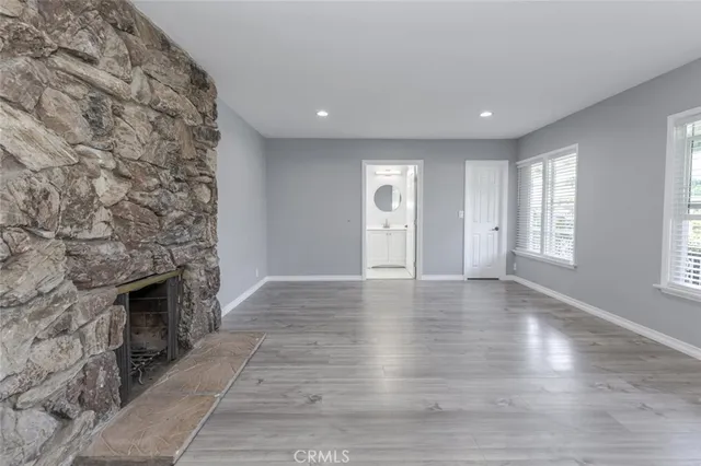 an empty room with windows and fireplace