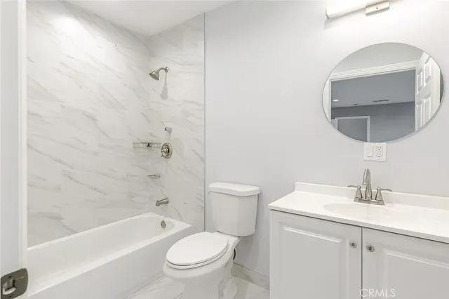 a bathroom with a toilet a sink a mirror and bathtub