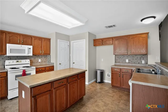 a kitchen with a stove a sink and a refrigerator