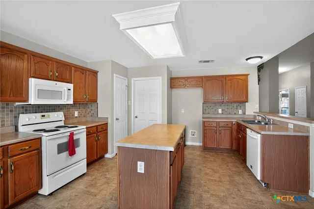 a kitchen with stainless steel appliances granite countertop a stove top oven