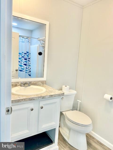 26 2nd Street Lothian, MD 20711 - Photo 11 of 27 a bathroom with a granite countertop toilet a sink and a mirror