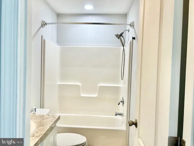 a bathroom with a granite countertop shower and a toilet