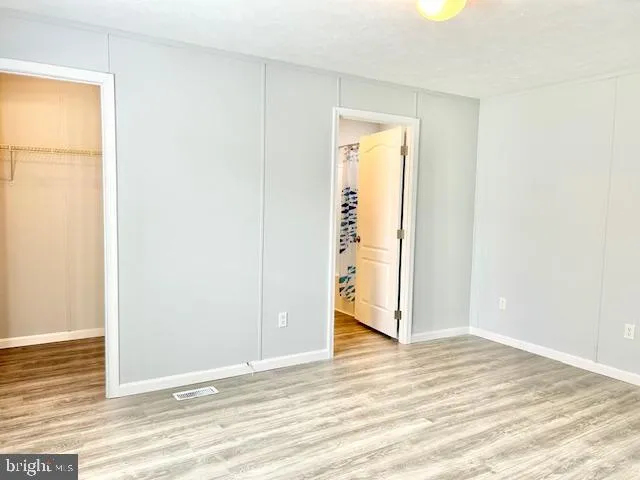 an empty room with wooden floor and closet