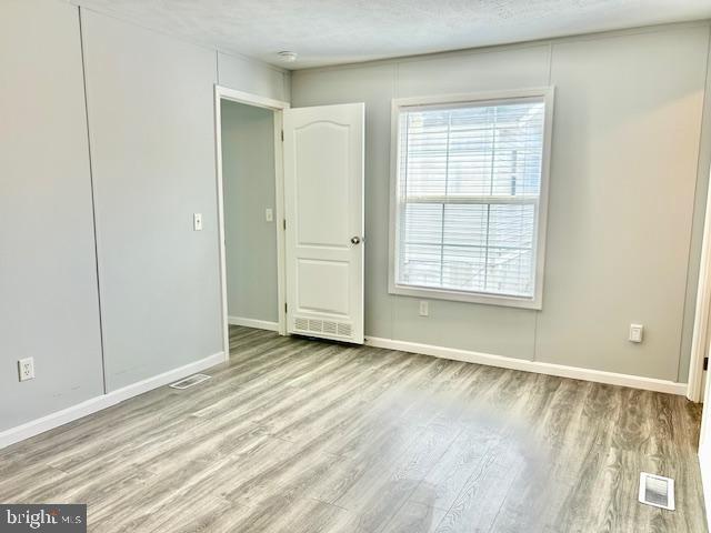 26 2nd Street Lothian, MD 20711 - Photo 9 of 27 an empty room with wooden floor and windows