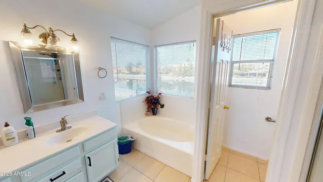 a bathroom with a tub sink and mirror