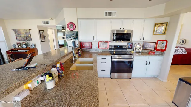 a kitchen with stainless steel appliances granite countertop a sink dishwasher stove and microwave