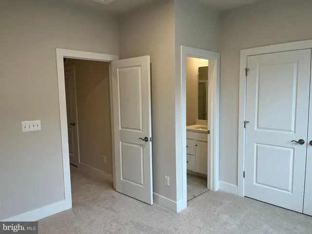 a view of an empty room with closet and entryway