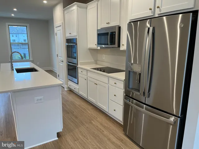 a kitchen with stainless steel appliances a refrigerator sink and microwave