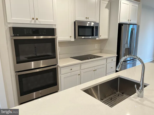 a kitchen with stainless steel appliances a stove microwave and refrigerator