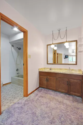 a spacious bathroom with a granite countertop sink and a mirror