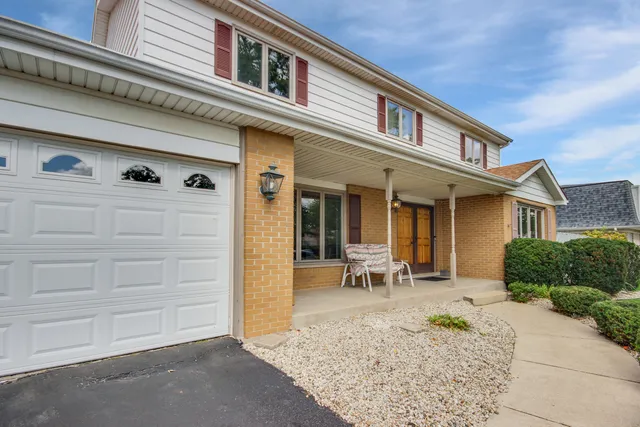a front view of a house with outdoor seating and a potted plant