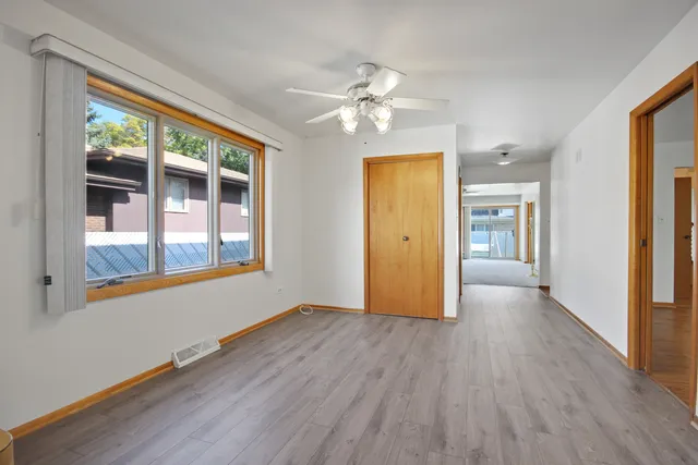 a view of an empty room with window and wooden floor