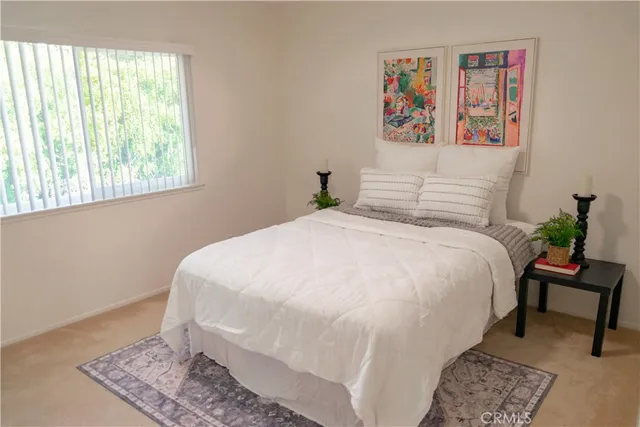 a large white bed in a bedroom next to a window
