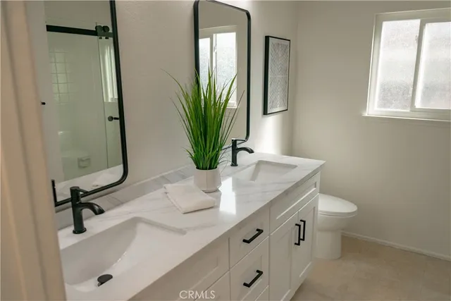 a bathroom with a granite countertop sink a toilet and a mirror