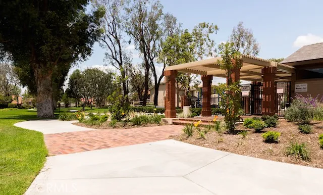a row of palm trees sitting in a park with trees