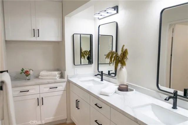 a bathroom with cabinets sink and a mirror