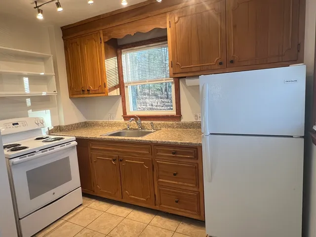a kitchen with a refrigerator sink and cabinets