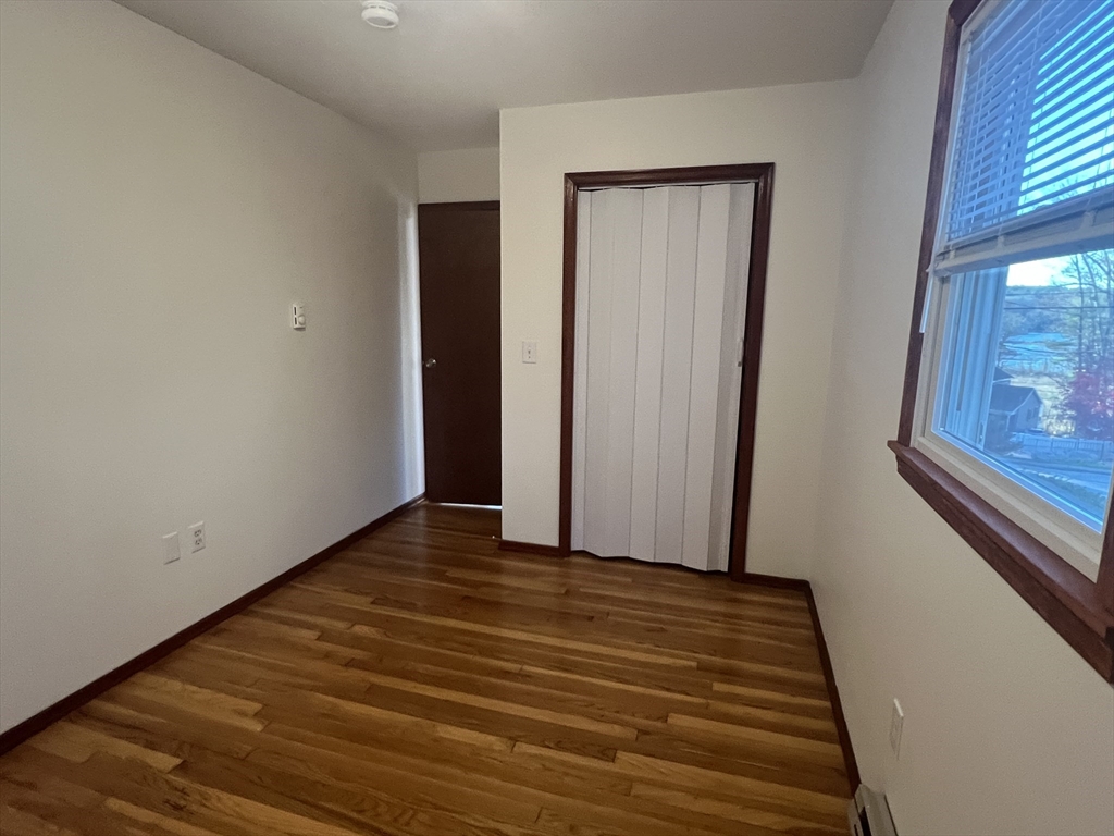 5 2nd Road, Unit 5 Hopkinton, MA 01748 - Photo 14 of 19 a view of an empty room with wooden floor and a window