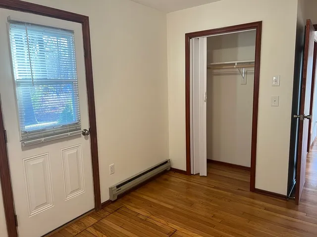 a view of empty room with wooden floor and window