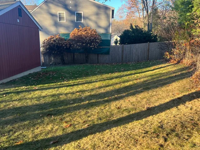 a view of backyard with wooden fence