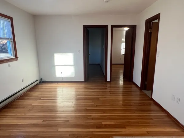 a view of a room with wooden floor and window