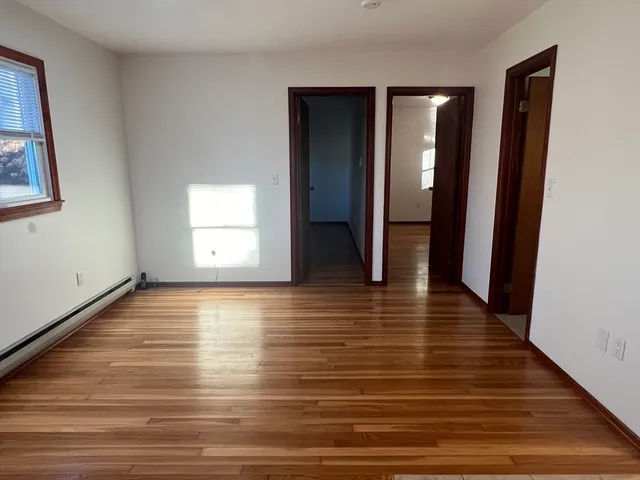 a view of a room with wooden floor and window