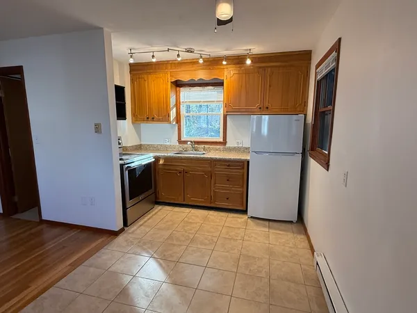 a kitchen with stainless steel appliances granite countertop a stove a sink and a refrigerator