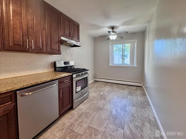 an empty room with kitchen appliances and wooden floor